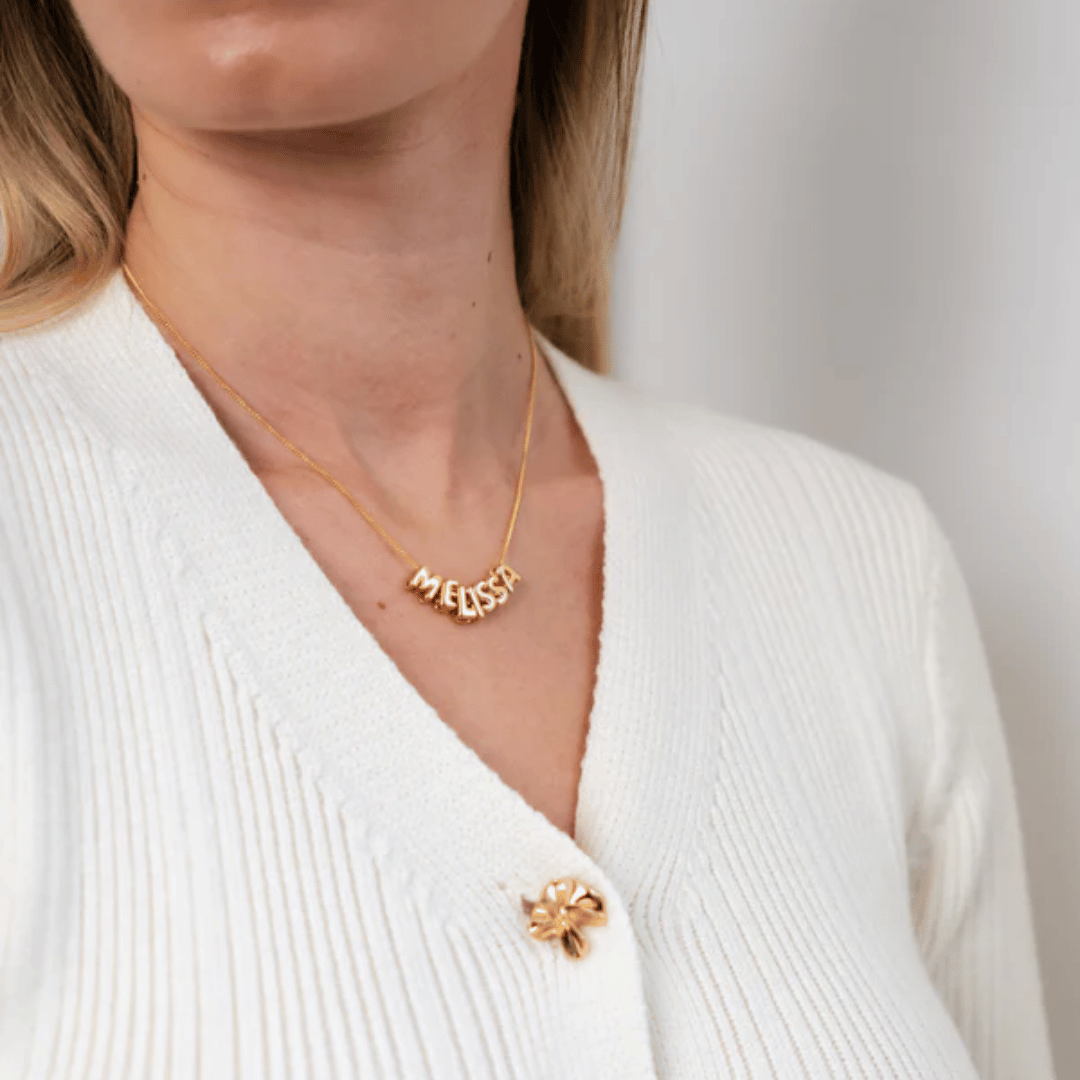 woman wearing gold personalised bubble letter necklace – layered and statement style