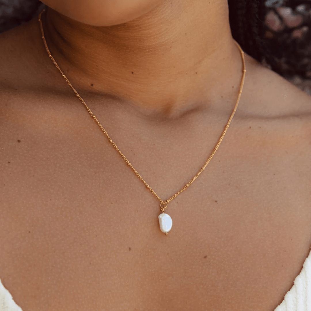 Model layering Moonela pearl pendant with other gold necklaces – soft feminine jewelry