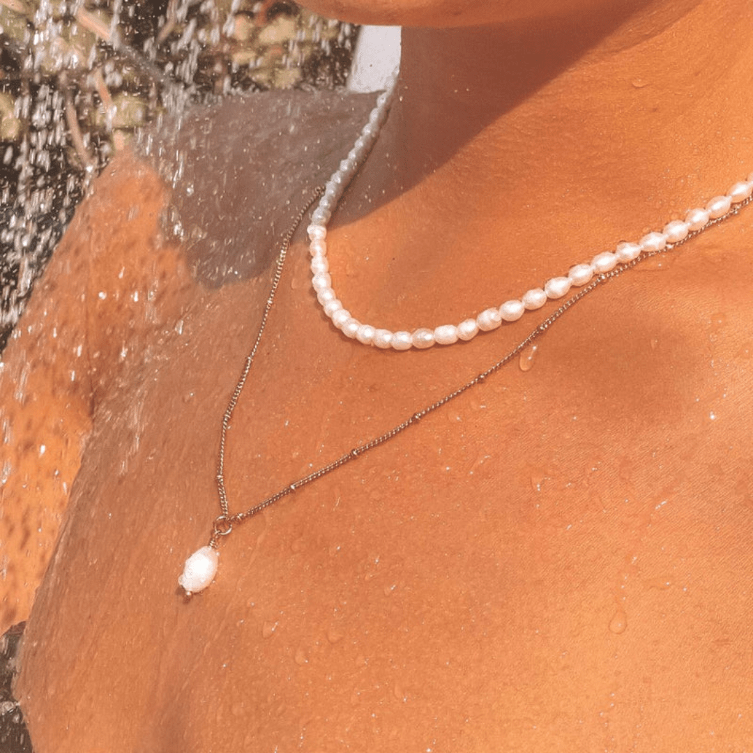 Close-up of neck and collarbone with Moonela baroque pearl pendant – refined details