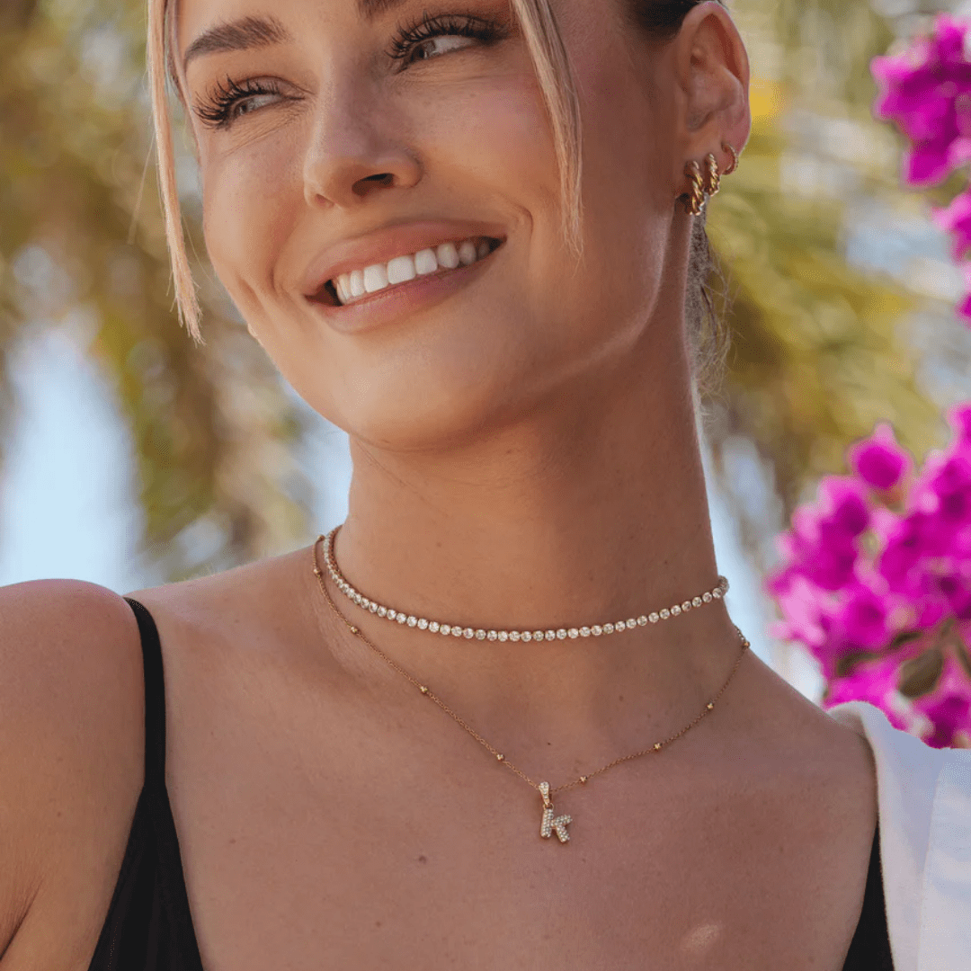 smiling woman wearing tennis necklace with gold zirconia – elegant jewellery for summer